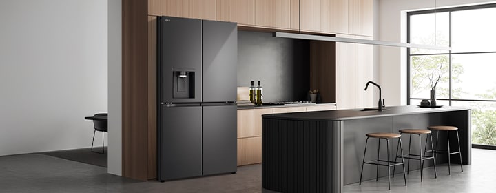 LG fridge freezer with water dispenser installed in a modern kitchen interior with island and natural light.