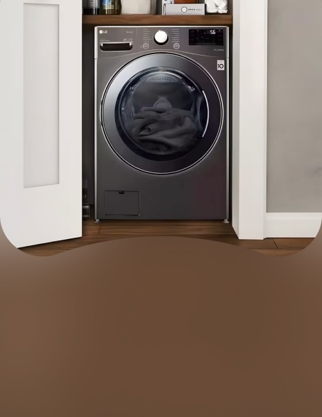 Woman loading laundry into built-in LG washing machine in modern laundry area