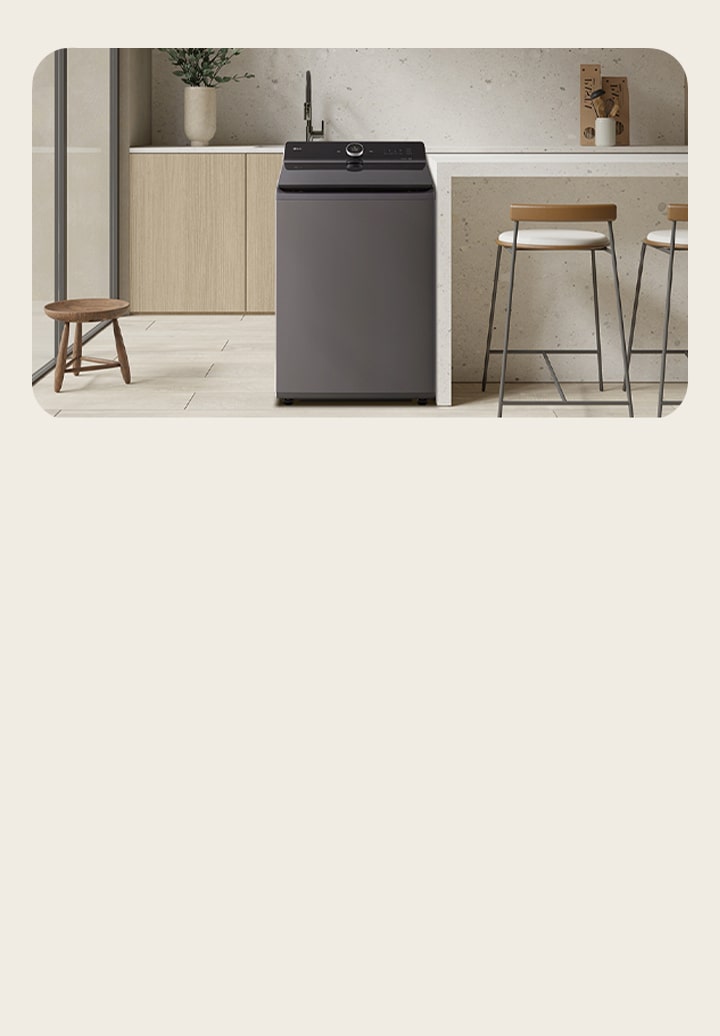 he top loading washing machine is located in the middle of a modern light brown interior There is a large window on the left and a high chair on the right