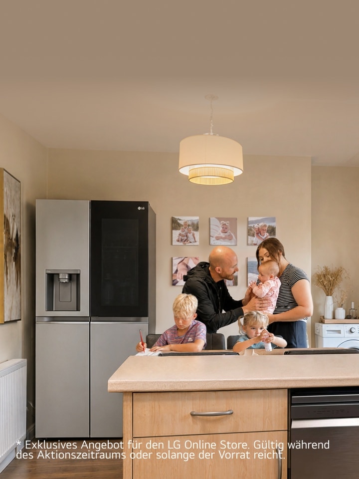 Eine Familie versammelt sich in einer Küche neben einem Edelstahl-LG-Kühlschrank – ein Junge schreibt am Esstisch, ein junges Mädchen sitzt neben ihm mit einer kleinen Flasche, und Eltern stehen zusammen und halten ein Baby.