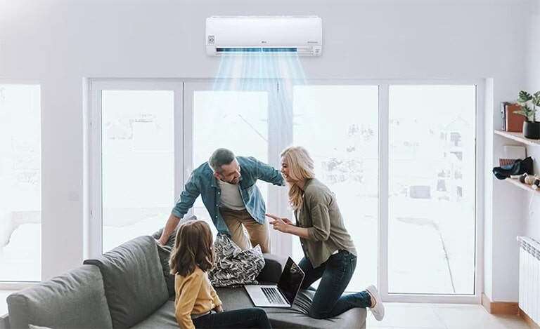 Installés dans leur salon, tous les membres d’une famille sont heureux de profiter de la ventilation fraîche de leur climatiseur.