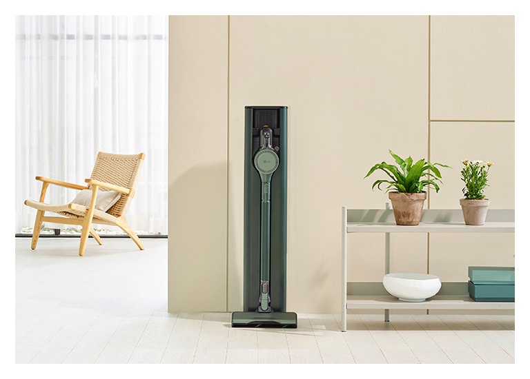 畫面顯示置於現代客廳的蒼林綠的 LG Objet Collection A9TS 蒸氣無線吸塵機。