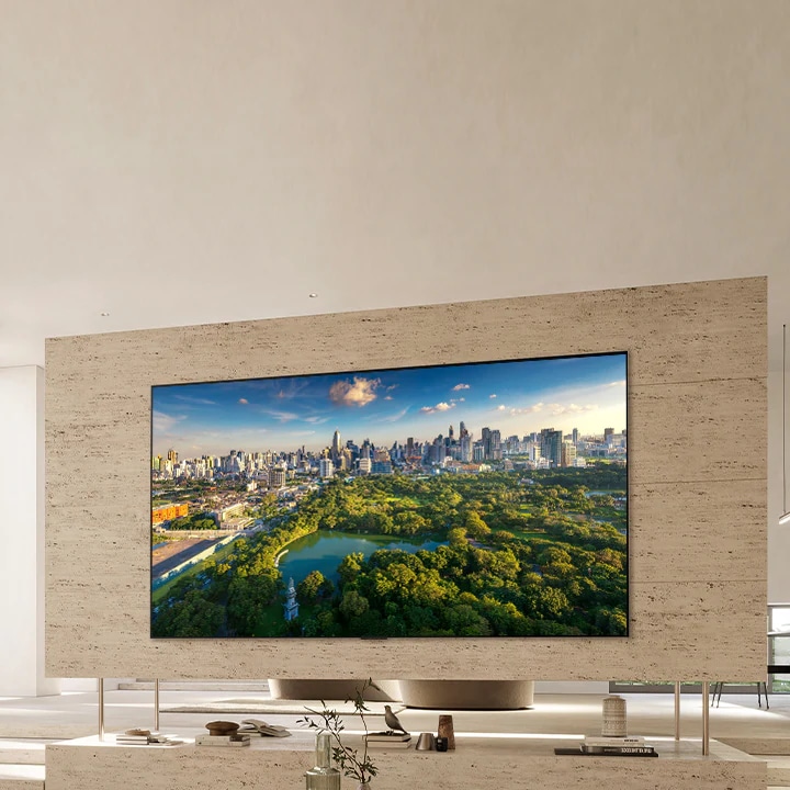 Ультрабольшой телевизор закреплен на стене современной гостиной.	