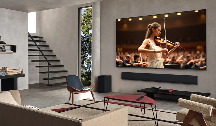 Living room with an LG TV and LG Soundbar. On the screen is a concert. A violinist is in front, behind her is an orchestra. Concentric circles emanate from the TV showing how AI Acoustic Tuning scans the room and adjusts sound to your space.