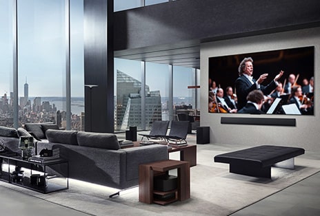 Salon z LG True Wireless TV i LG Soundbar zamontowanym na ścianie. Moduł Zero Connect Box jest łatwy do ukrycia i ledwo widoczny pod stolikiem obok kanapy. Cała aranżacja salonu jest estetyczna i uporządkowana.