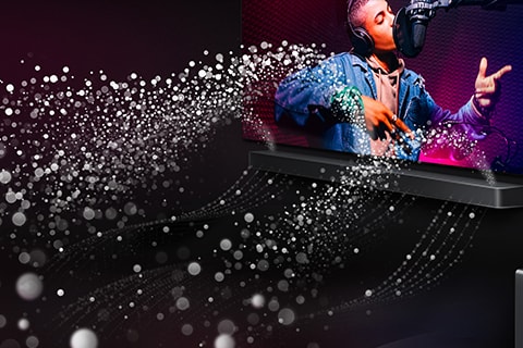 LG TV i LG Soundbar w czarnym pokoju. Odtwarzany jest występ muzyczny. Białe krople reprezentujące fale dźwiękowe tryskają w górę i do przodu z soundbara.