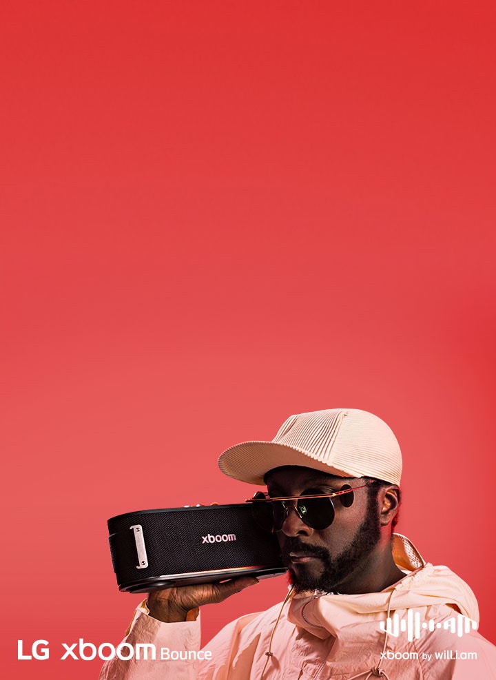 Beyaz bir kıyafet giyen ve güneş gözlüğü takan will.i.am yüzünün hemen yanında xboom Bounce tutuyor.