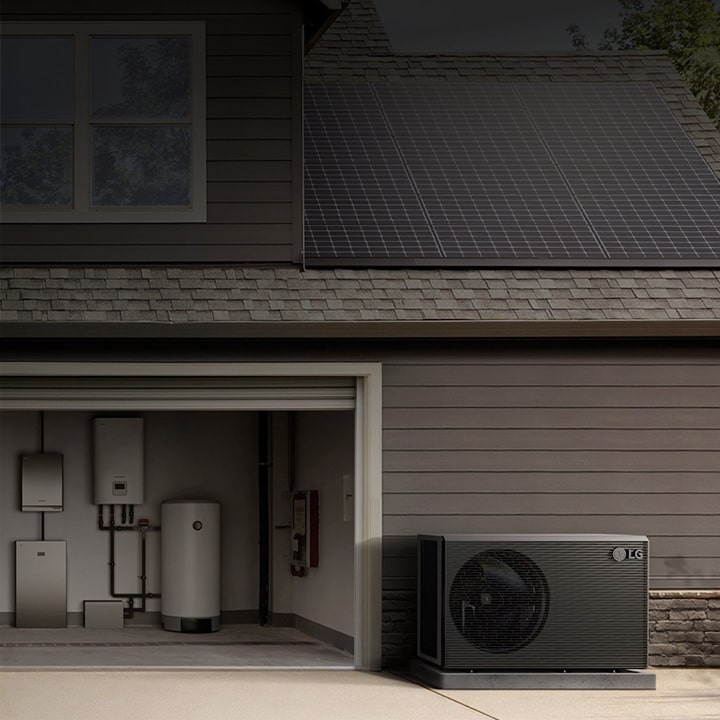 Unit luar HVAC terpasang di samping garasi sebuah rumah modern dengan sistem pompa panas dan boiler di dalamnya