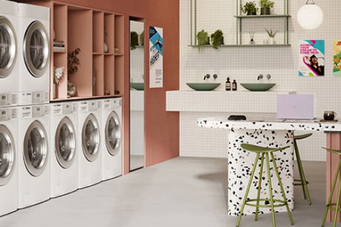 Interior lounge laundry swalayan modern dengan mesin cuci dan pengering LG serta area duduk bergaya bar