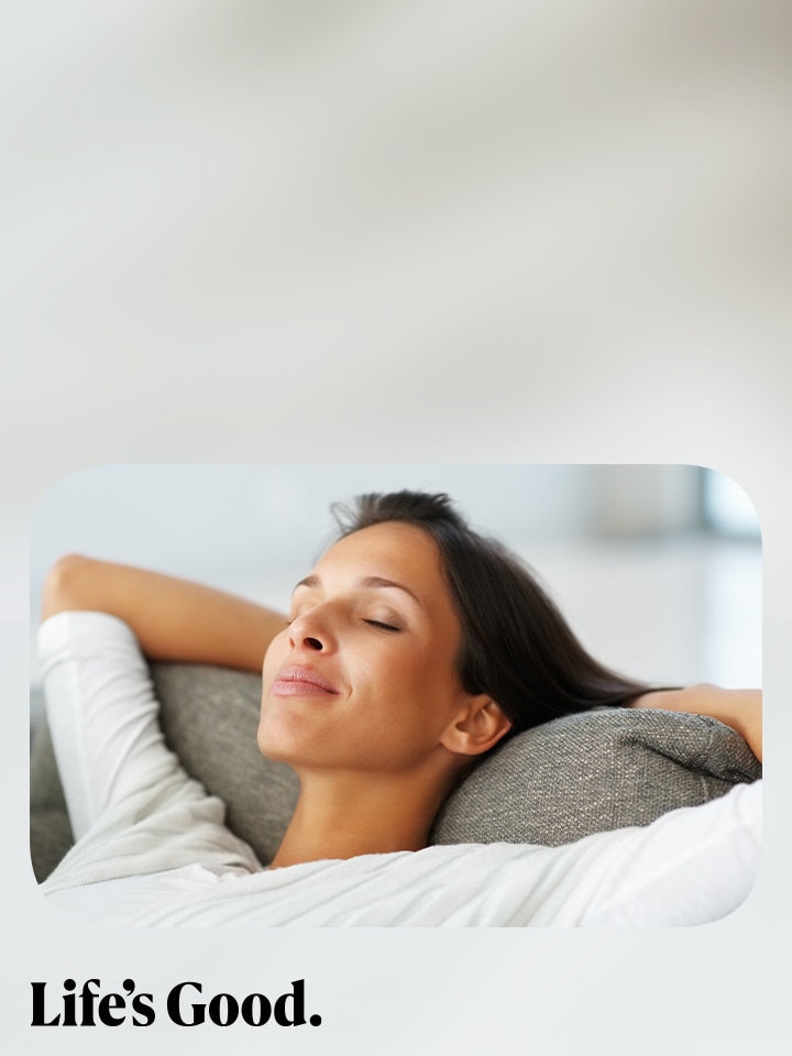 En kvinna som kopplar av i en soffa med händerna bakom huvudet, ögonen slutna och ett fridfullt uttryck. Längst ned i bilden står texten ”Life’s Good.”