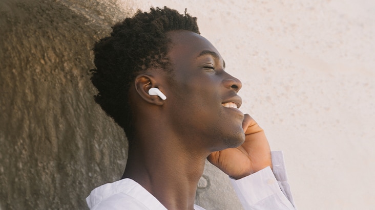 A man is wearing T60 earbuds and listening to music with his eyes closed.