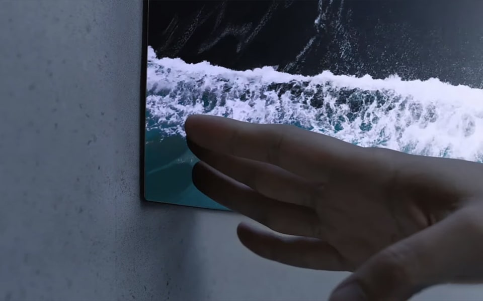 Eine Hand berührt einen ultradünnen LG OLED-Fernseher.