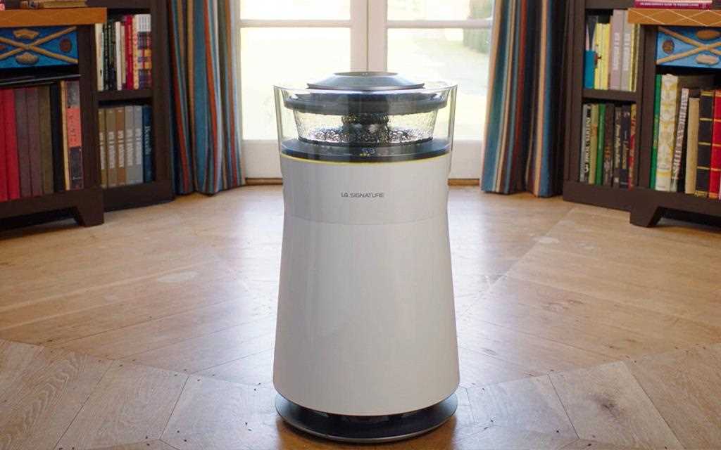 A front view of the LG SIGNATURE air purifier in a room with a bookcase in the background