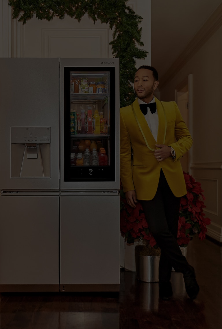 El cantante John Legend apoyado en un refrigerador LG SIGNATURE.