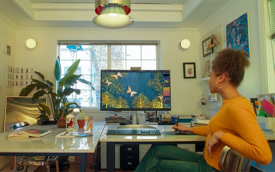 O femeie folosește un monitor curat în biroul ei de acasă