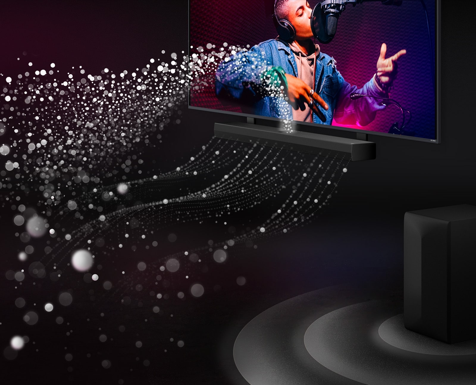 LG Soundbar and LG TV in a black room playing a musical performance. White droplets representing soundwaves shoot upwards and forward from the soundbar. A subwoofer is creating a sound effect from the bottom.