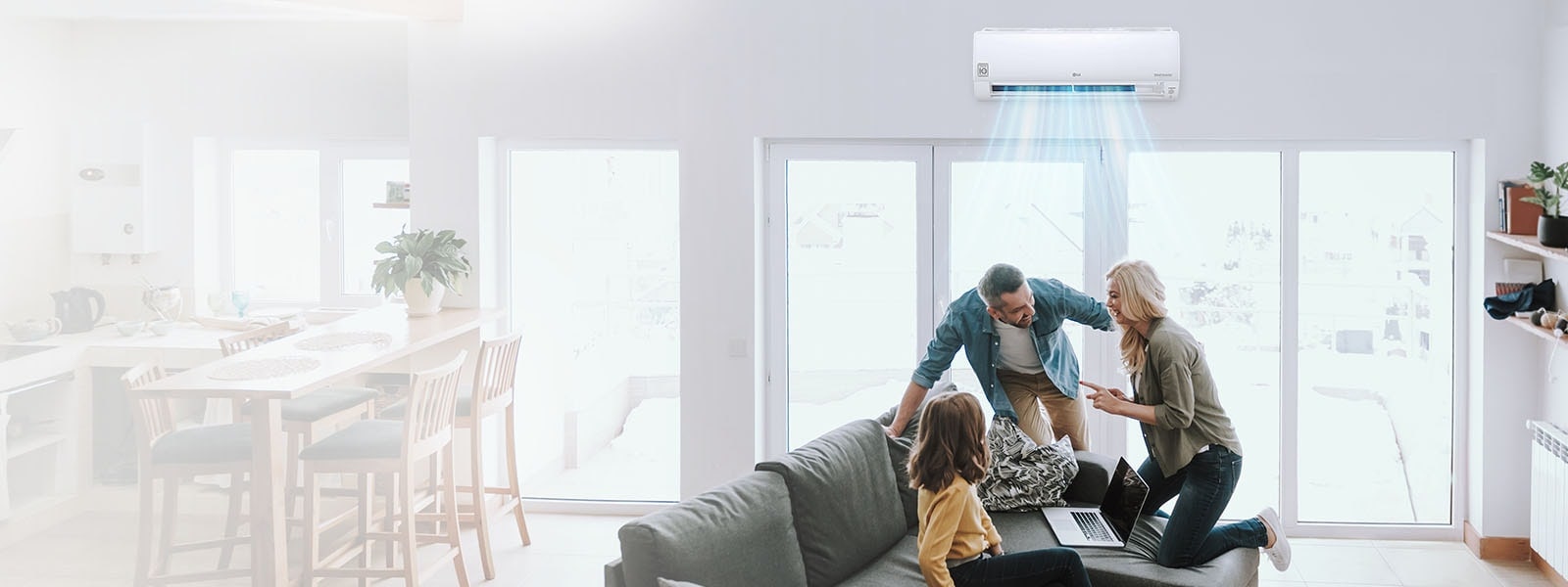 A joyful family, father mother and a young daughter, is having a conversation on a living room sofa, LG hvac wall-mounted air conditioner(AC) providing cool comfort to all.