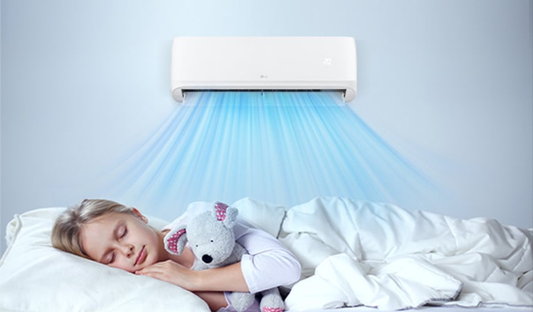 The air conditioner is operating. Below it, a girl is sleeping comfortably holding a doll.