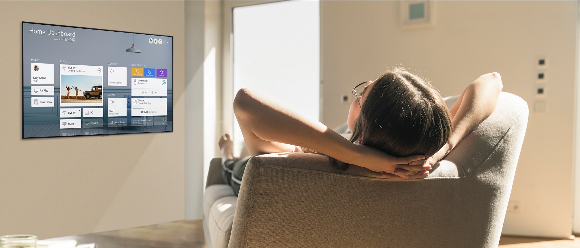 Woman lying on a sofa telling TV to lower the temperature with Home Dashboard on the TV screen