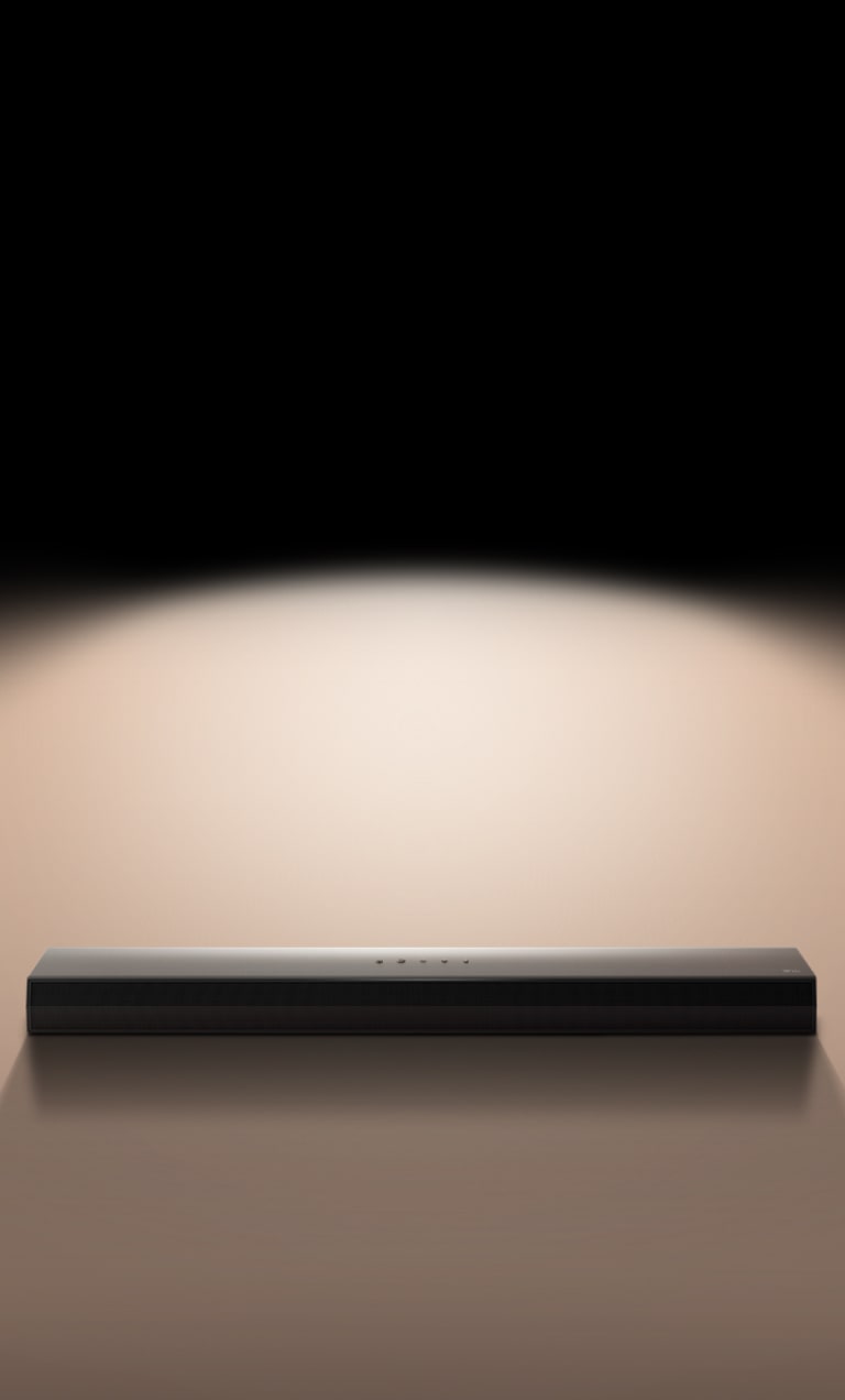 يظهر مكبر الصوت LG Soundbar على خلفية سوداء مظللة بضوء موجَّه. 