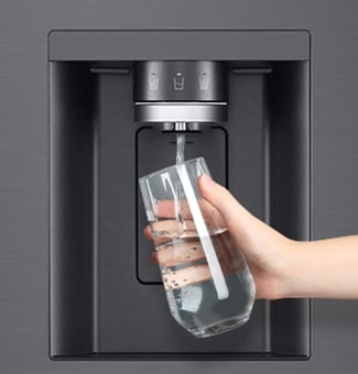 A person is getting water from the refrigerator dispenser in a cup