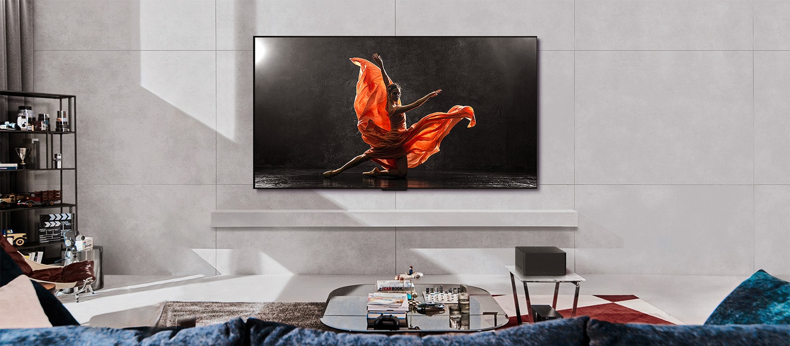 LG SIGNATURE OLED M4 and LG Soundbar in a modern living space in daytime. The screen image of a dancer on a dark stage is displayed with the ideal brightness levels.