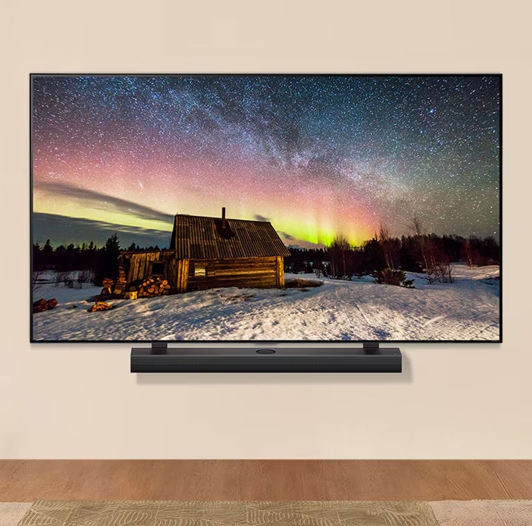 LG TV and LG Soundbar in a modern living space in daytime. The screen image of the aurora borealis is displayed with the ideal brightness levels.