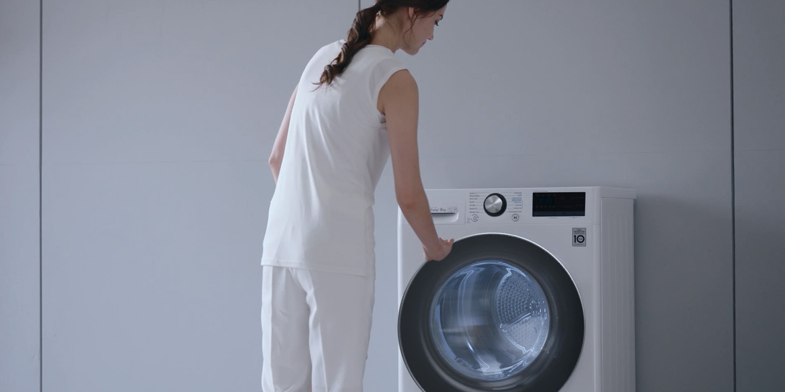 Femme debout devant un sèche-linge LG