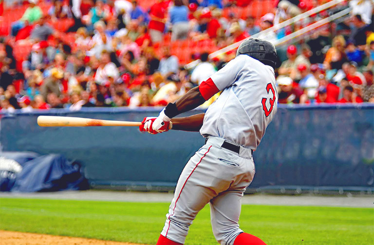 Un joueur de base-ball lance la batte durant un match devant la foule dans un stade.