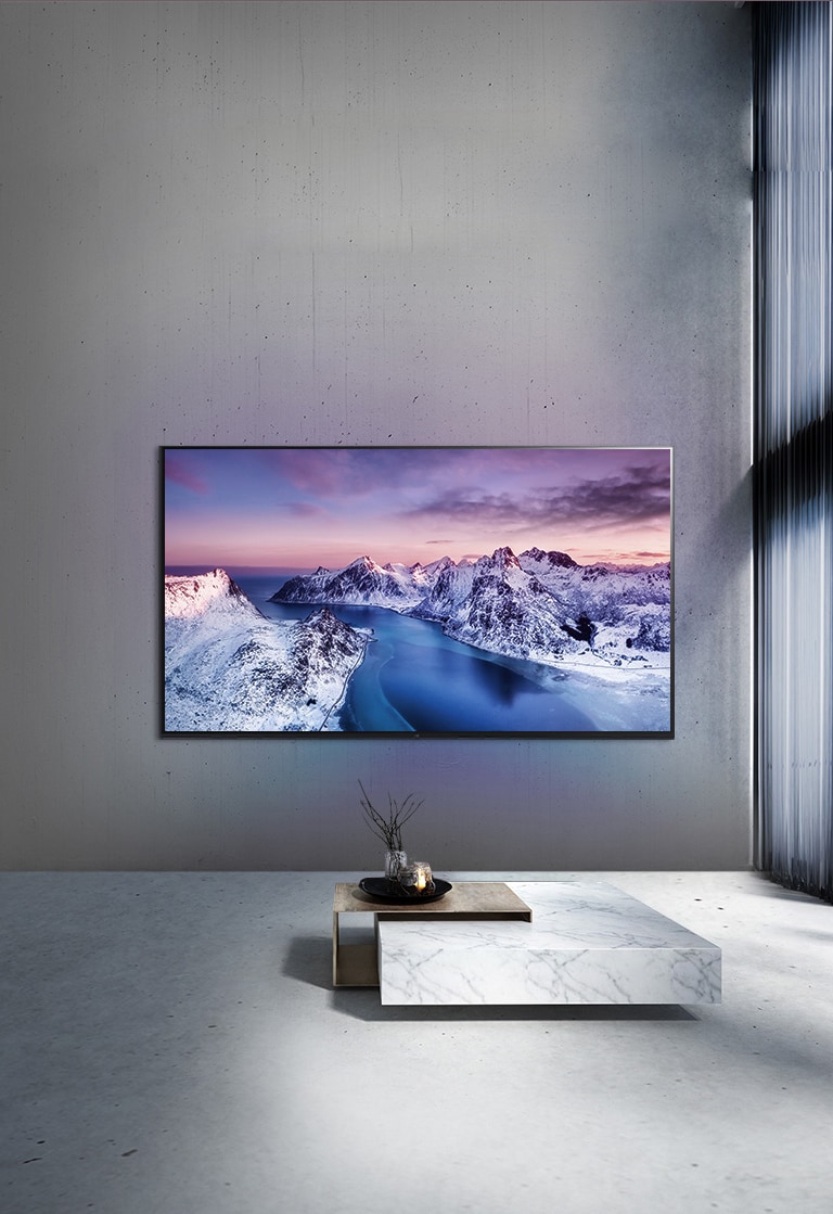 Un televisor UHD montado en la pared detrás de una mesa con ambientación de estilo zen.