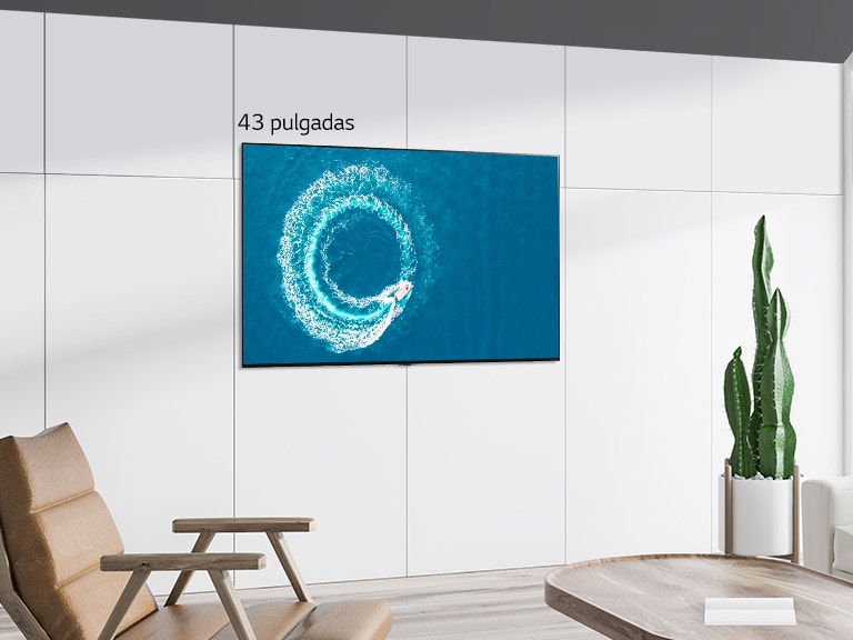 Televisor LG QNED Mini LED montado en la pared en un espacio blanco moderno. Al desplazarse de izquierda a derecha se puede ver la diferencia en tamaño entre la pantalla de 43 pulgadas y la de 86 pulgadas.