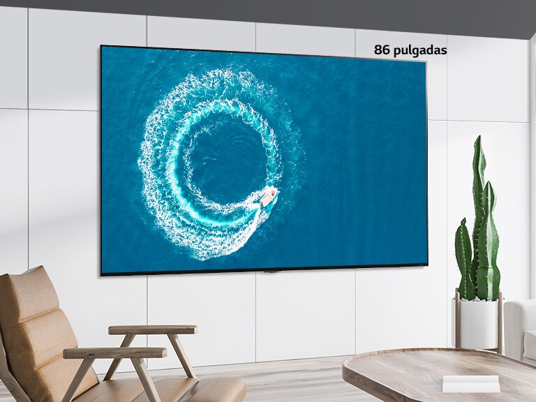 Televisor LG QNED Mini LED montado en la pared en un espacio blanco moderno. Al desplazarse de izquierda a derecha se puede ver la diferencia en tamaño entre la pantalla de 43 pulgadas y la de 86 pulgadas.