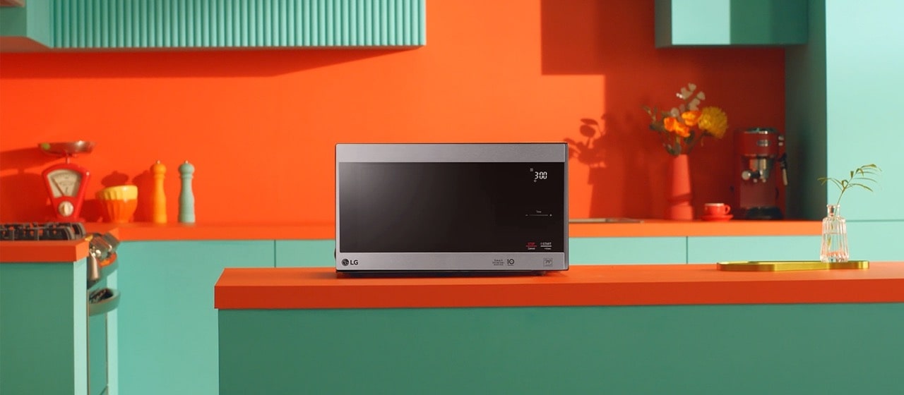 LG Neochef® microwave oven placed in bright orange and green modern design kitchen.