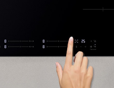 Touching the control panel of the induction cooktop.