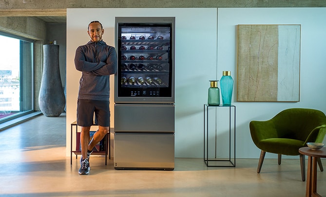 Lewis Hamilton leaning against the LG SIGNATURE Wine Cellar.