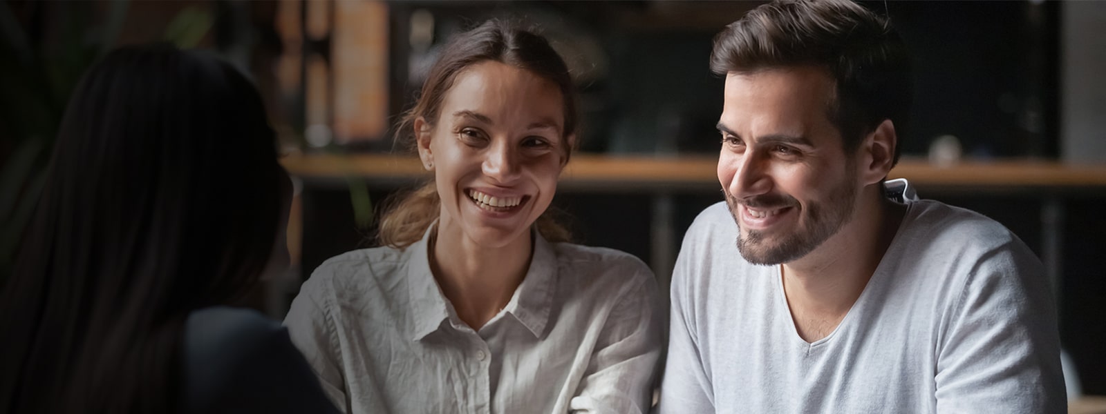 Un homme et une femme parlent à une autre femme en face d’eux