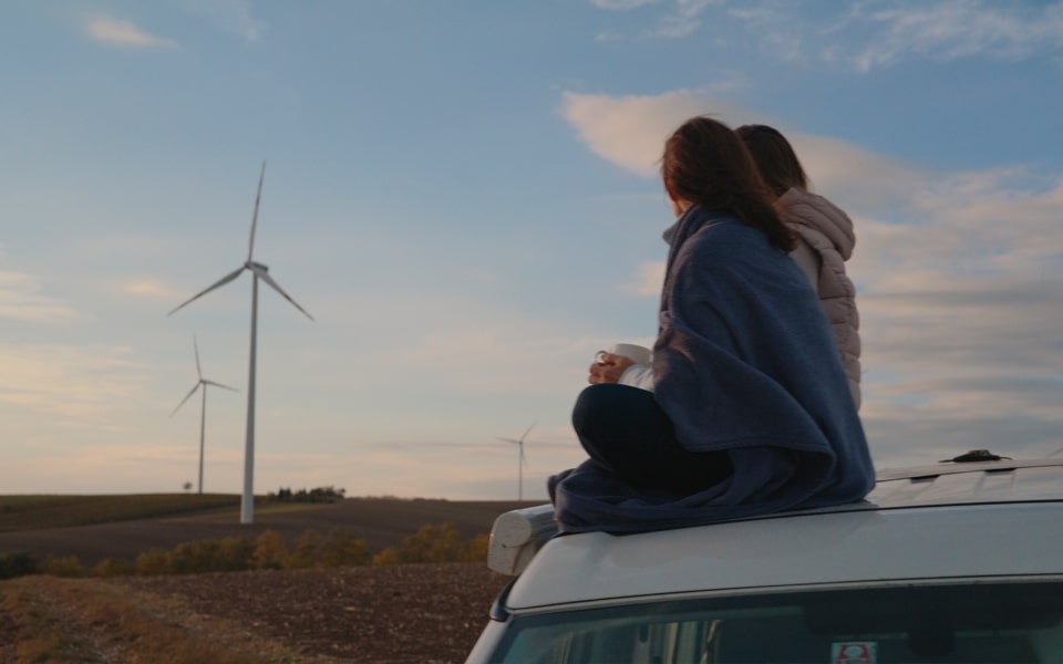 young consumer in a field with wind turbines