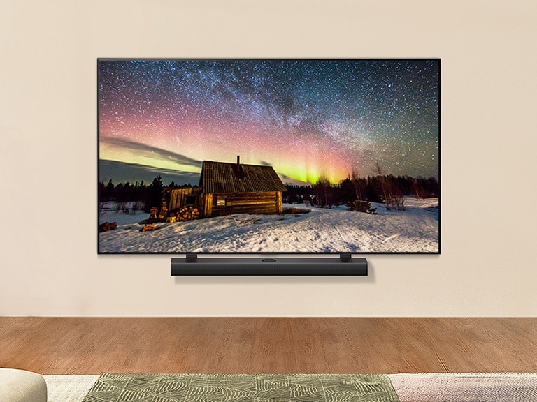 LG TV y una barra se sonido LG en un espacio moderno durante el día. La imagen de la aurora boreal se muestra con los niveles de brillo ideales