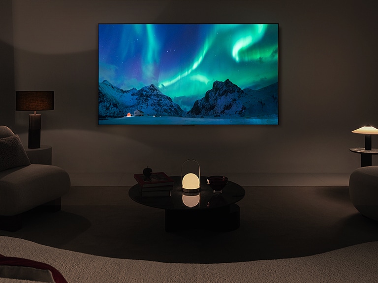 El televisor LG OLED y una barra de sonido LG en un espacio moderno durante la noche. La imagen de la aurora boreal se muestra con los niveles de brillo ideales.