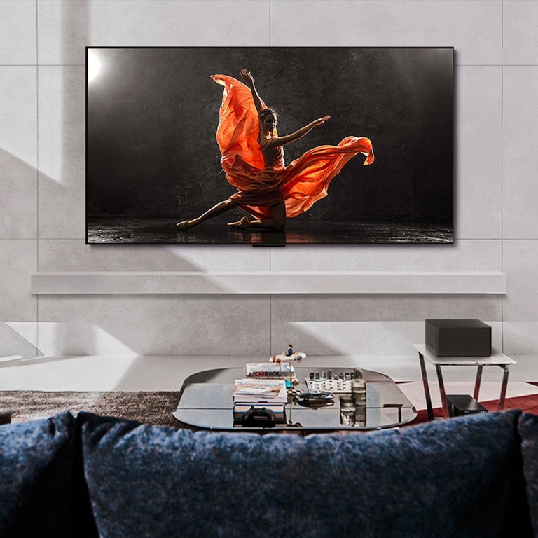 Un LG OLED evo M4 y una LG Soundbar en un espacio de estar moderno durante el dia. La pantalla con la imagen de un velero en el mar se muestra con los niveles de brillo ideales.