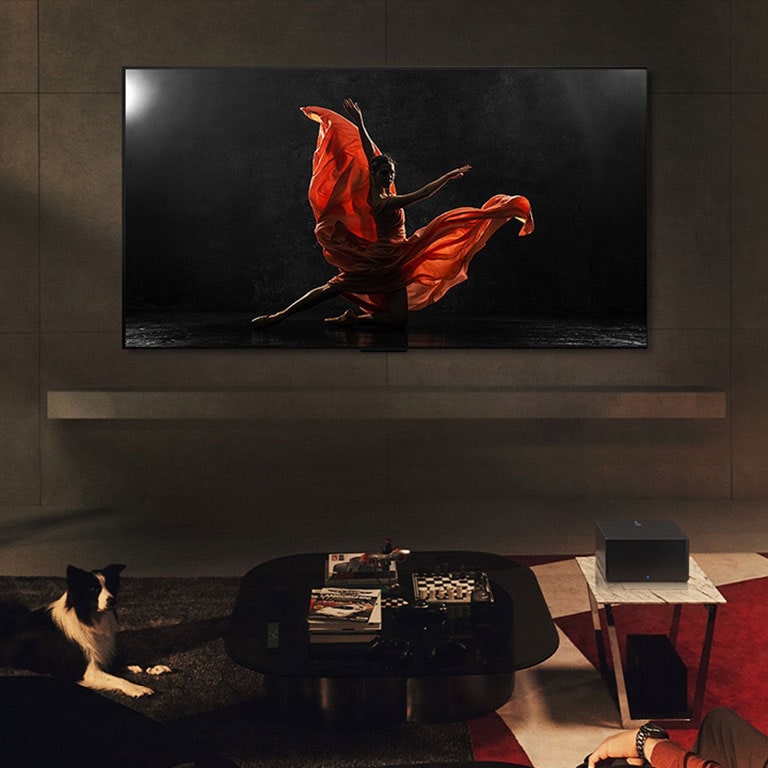 Un LG OLED evo M4 y una LG Soundbar en un espacio de estar moderno durante la noche. La pantalla con la imagen de un velero en el mar se muestra con los niveles de brillo ideales.