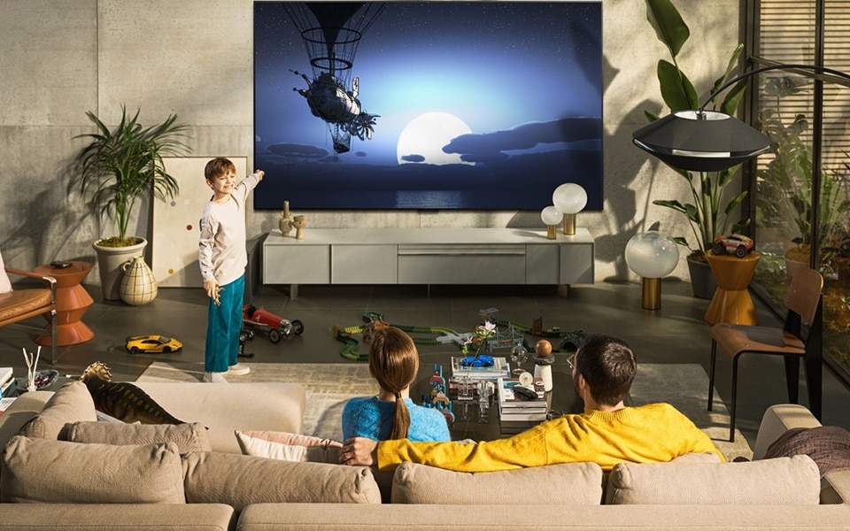Eine Familie sitzt mit dem richtigen Abstand zum Fernseher
