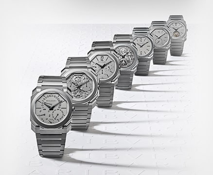 Sieben silberne BVLGARI Uhren diagonal angeordnet.