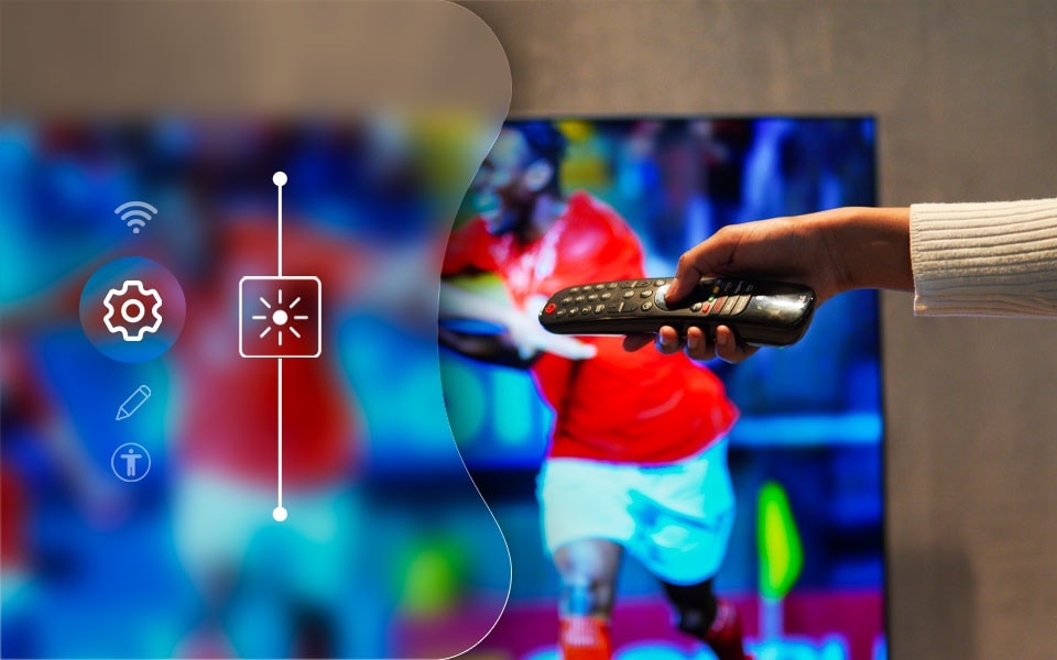 Une personne qui règle les paramètres de la télévision à l'aide d'une télécommande afin d'optimiser la visualisation des sports.