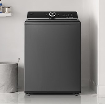 Lavadora de roupas de carregamento superior LG WT25WT6HK de 25 kg em uma lavanderia familiar com toalhas empilhadas.