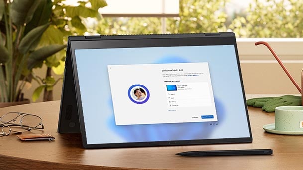 Esta imagen muestra una tableta con la pantalla de configuración de Windows 11 sobre un escritorio de madera, con una planta, un cuaderno y un bolígrafo cerca, lo que destaca la facilidad para transferir archivos.