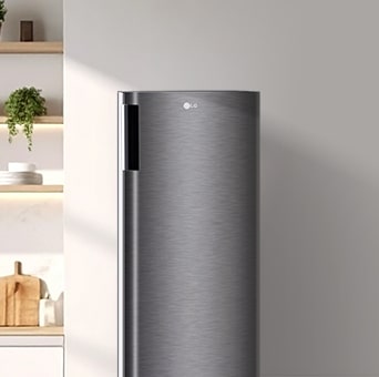 Hay un refrigerador LG alto de una puerta al lado de una pared minimalista.