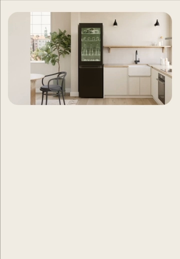 Congelador del refrigerador LG alto con frente de cristal en una cocina en tonos beige y madera. La puerta transparente deja ver estantes iluminados con luz verde con alimentos cuidadosamente organizados. Hay una mesa y una planta cerca.