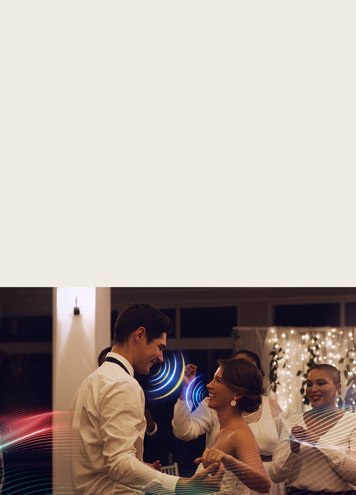 LG QNED evo AI QNED85 Mini LED with AI Object Remastering Pro shows a couple dancing at a lively indoor party, enhancing voices and key sounds amid surrounding music and crowd noise for clearer, more immersive audio.