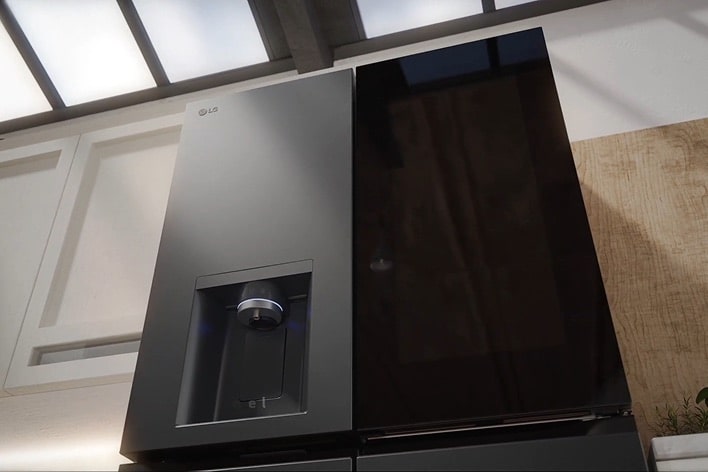 Close-up of LG InstaView refrigerator. The see-through panel lights up, followed by the water dispenser. The sleek handle is shown before the door opens.